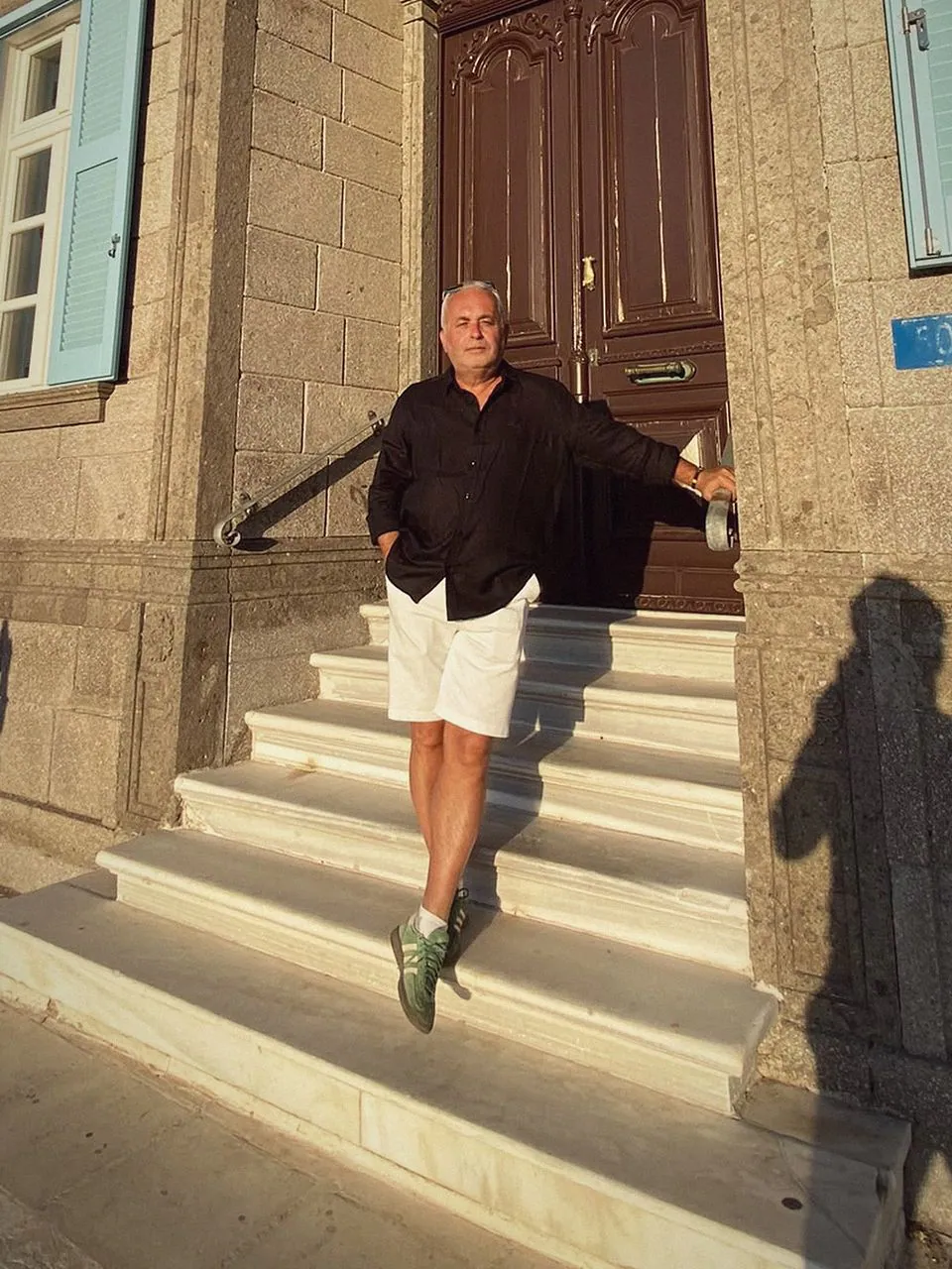 Cem Kongel tarihi bir binanın merdivenlerinde